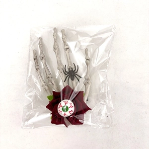 Détail de la pince à cheveux main de squelette avec rose rouge, araignée et œil