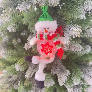 LED Christmas snowman ornament with warm light and long legs hanging on a snowy pine tree