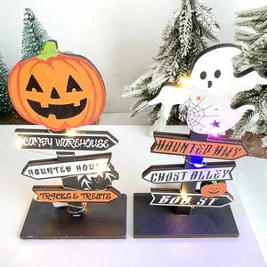 Detail of wooden Halloween pumpkin and ghost signs with warm LED fairy lights