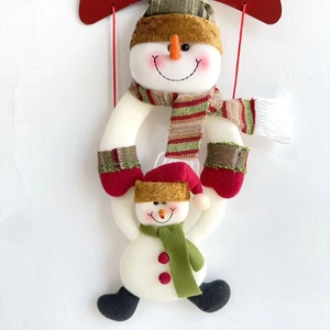 Detail eines hängenden Weihnachts-Schneemann-Plüschs mit rot-grünem Strickschal und Hut