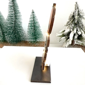 Side view of wooden snowman decor with warm white LED lights and a black base
