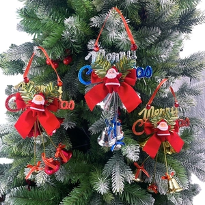Close-up of Santa Claus hanging ornaments with large red bows and metallic bells on a tree
