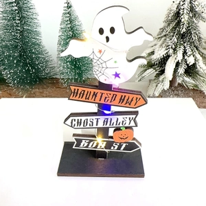 Close-up of lighted wooden Halloween road sign with pumpkin, ghost, and LED lights