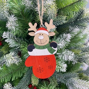 Close-up of wooden reindeer ornament in red mitten hanging on a snowy Christmas tree