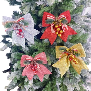 Detail of glitter Christmas bows with pine cones and berries on a green Xmas tree
