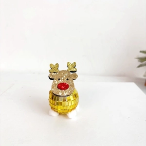 Close-up of golden disco ball reindeer decoration with glitter antlers and white plush feet