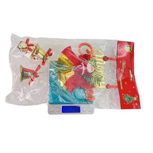Close-up of Santa Claus bell hanging ornament set on a scale weighing 35.3 grams