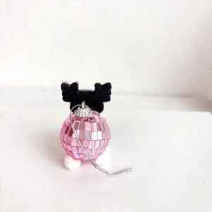 Close-up of pink disco ball ornament with black reindeer antlers for party decor