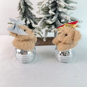 Close-up of teddy bear figurines with disco ball bases and festive holiday decorations