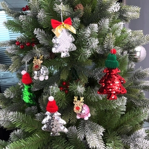 Close-up of sparkling reindeer disco ball and colorful tree ornaments on a snowy Christmas tree