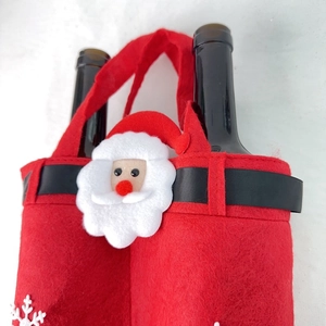 Detail of red felt Santa wine gift bags with black belt and snowflake embroidery