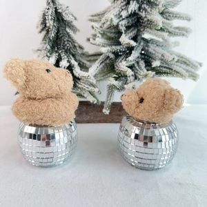 Close-up of plush teddy bear heads on silver disco ball bases for Christmas decor
