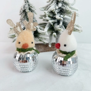 Close-up of shiny disco mirror mosaic reindeer figurines with festive knitted scarves
