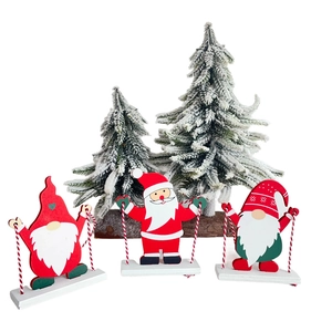 Tre gnomi natalizi in legno e Babbo Natale su altalene con piccoli pini decorativi