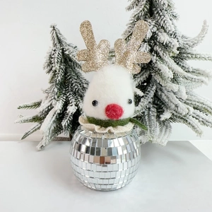 Macro shot of a felt Christmas reindeer figurine with a silver disco ball mirror base