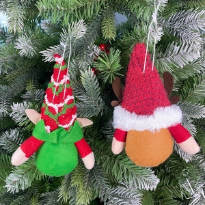 Detail of Christmas gnomes hanging on a tree with knitted hats and reindeer antlers