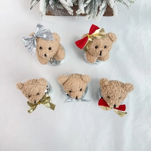 Close-up of five brown plush teddy bears with festive bows on silver disco ball bases