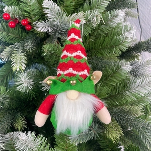 Close-up of Christmas gnome ornament with red knit hat and bells on tree