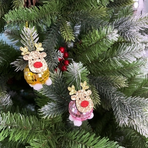 Close-up of glittery elk disco ball ornaments hanging on a festive Christmas tree branch