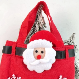 Detail of red felt Christmas gift bag featuring a 3D Santa Claus and snowflake applique
