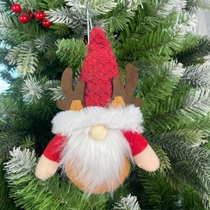 Close-up of a Christmas gnome ornament with reindeer antlers hanging on a tree