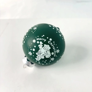 Close-up of green matte Christmas ball with Santa Claus print and silver metal hook
