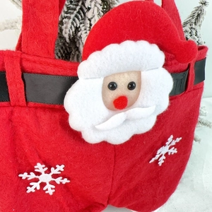 Detail of red Santa Claus gift bag with felt 3D character and white snowflake patterns