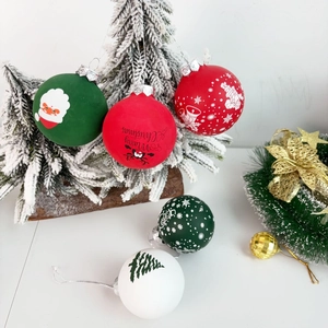 Frosted Christmas ball set with Santa and snowflake prints hanging on a snowy tree