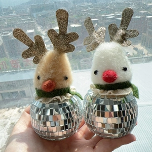 Close-up of handmade wool felt bird ornaments with disco mirror bases and gold antlers