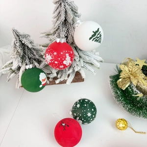 Close-up of PET Christmas balls with reindeer and snowflake prints on a snowy tree