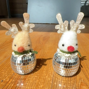 Detail of Christmas reindeer decor with disco ball base and plush head in festive colors