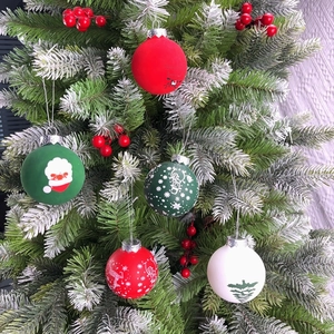 Close-up of festive PET Christmas ball ornaments with Santa and reindeer on a tree branch