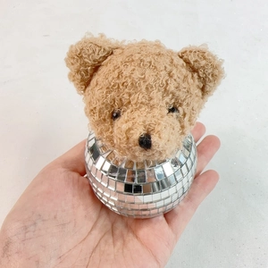 Detail of a disco mirror ball bear ornament with plush head and reflective silver facets