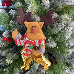 Close-up of a Christmas reindeer ornament with gold sequins and a red knitted scarf
