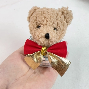Detail of a Christmas disco bear ornament featuring a red bow and mirror mosaic tiles