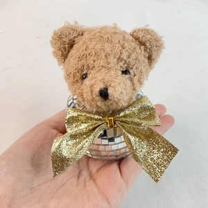 Detail of a Christmas bear ornament with a disco mirror ball body and plush head