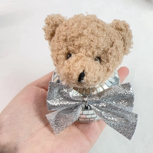 Detail of disco mirror mosaic ball and plush teddy bear with shiny silver sequin bow