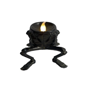 Macro detail of skeleton leg candle holder with glowing LED candle for Halloween decor