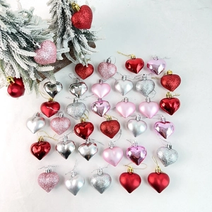 Close-up of heart-shaped ornaments with glitter and matte finishes for festive decoration