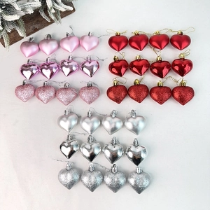 Detail view of 24 heart-shaped ornaments in pink, red, and silver with glitter finish