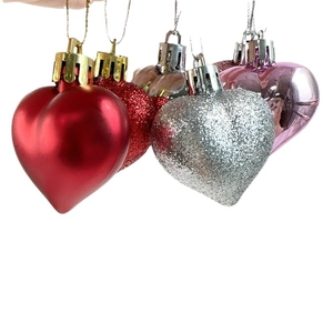 Detail of multi-finish heart ornaments with matte and glitter surfaces for holiday decor