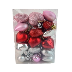 Close-up of heart-shaped ornaments with glitter, matte and glossy finishes in a clear box