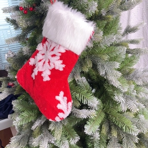 Close-up of a festive red Christmas stocking with white snowflake embroidery and plush trim