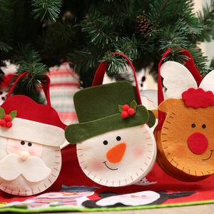 Detail of Christmas felt candy bags with Santa and Snowman hanging on a festive tree