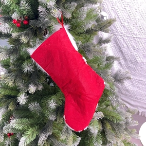 Classic red Christmas stocking with white faux fur trim hanging on a pine tree