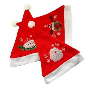 Three Christmas velvet hats with Santa, snowman and reindeer embroidery on white background