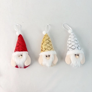 Close-up of three plush Christmas gnomes with sequined hats and white hanging strings