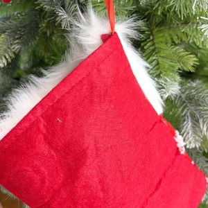 Detail of red felt Christmas stocking with white faux fur cuff and stitching details