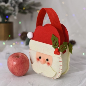 Detail of felt Santa candy bag with red apple on festive background with warm lights
