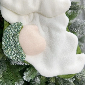 Detailed close-up of a Christmas stocking featuring plush white beard and woven green textures